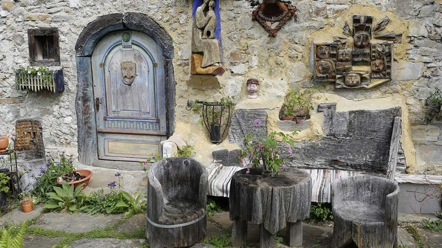 Alte Möbel und Gerümpel vor einer Steinmauer
