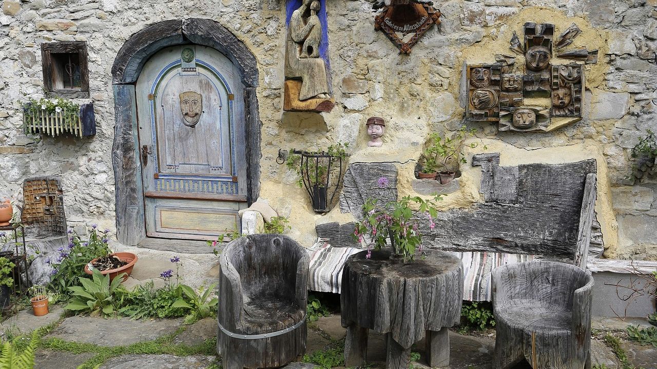 Alte Möbel und Gerümpel vor einer Steinmauer