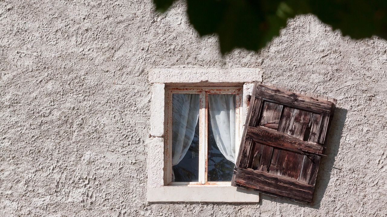 Verputzte Hauswand mit kleinem Fenster