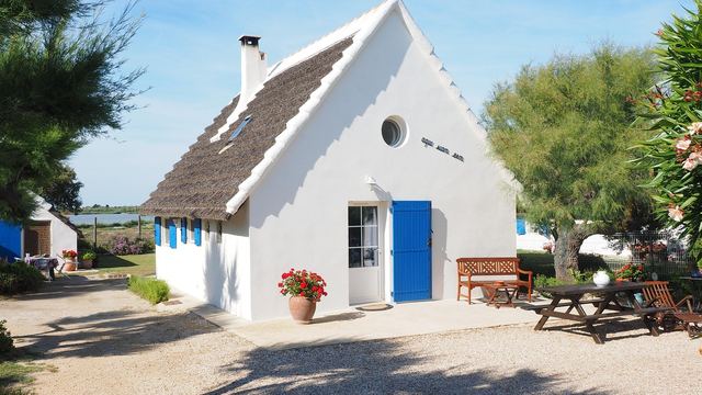 Weißes Ferienhaus mit blauer Tür